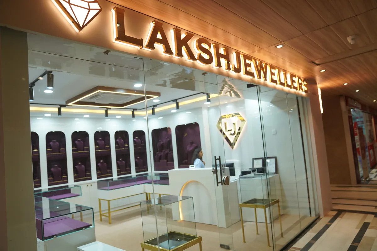 Laksh Jewellers showroom front with lit gold sign and arched velvet display niches