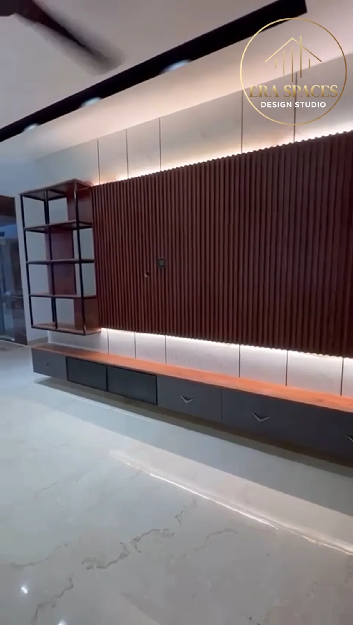 Living area wall of slatted wood panelling with open metal-framed shelving and a floating console