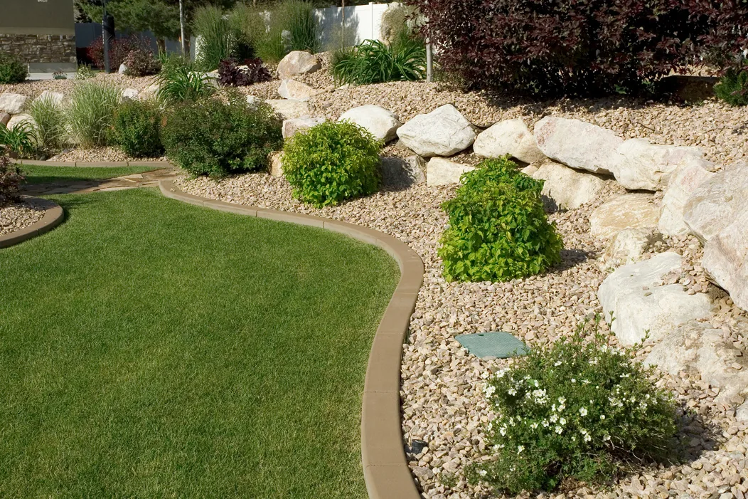 Lawn edged with a gravel and boulder rock garden